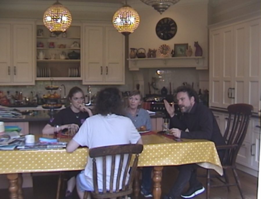 A family around a kitchen table with a yellow polka-dot cloth